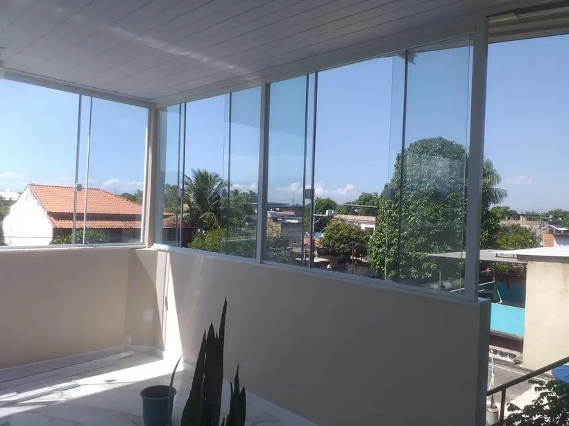 Varanda envidraçada com vista externa em obra residencial