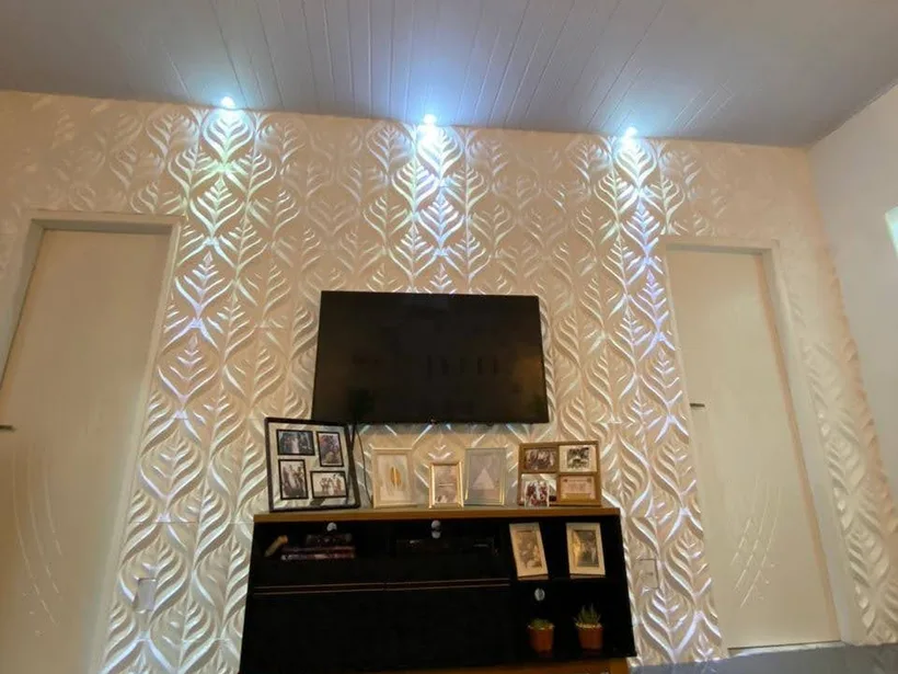 Sala residencial finalizada com painel de TV e revestimento iluminado