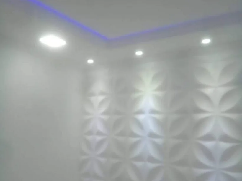 Parede com revestimento 3D e iluminação superior