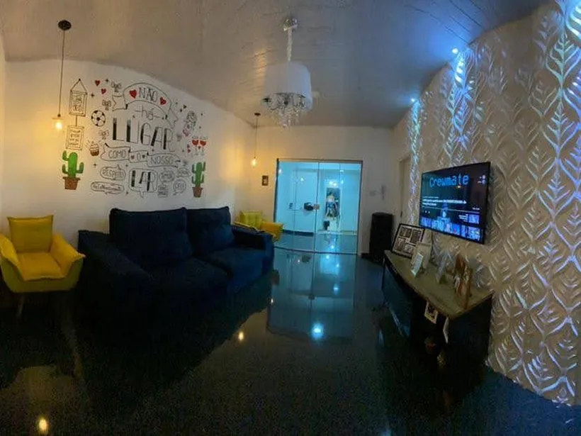 Sala integrada com iluminação decorativa e painel de TV